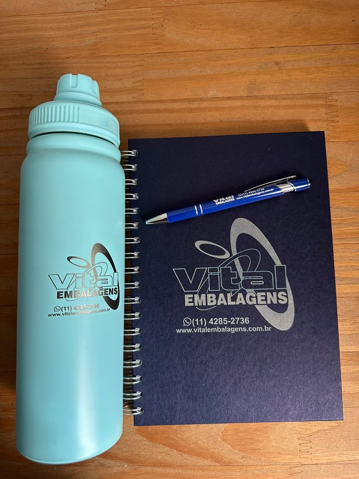 Garrafa térmica e caderno com a marca Vital Embalagens gravada a laser