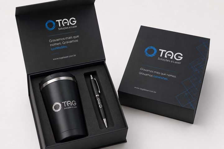 Caixa de presente personalizada com a marca da TAG, aberta com copo térmico e caneta gravados a laser.